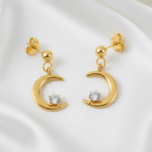 Gold earrings with moon designs and clear stones on a white background