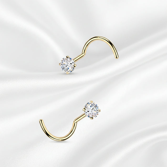 Set of gold and silver nose rings with clear gemstones on a white background