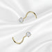 Set of gold and silver nose rings with clear gemstones on a white background