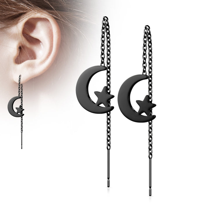 Black moon and star earrings with chain details worn by a person.