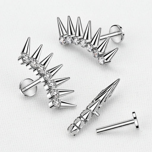 Silver spike earrings with clear gemstones on a light gray background