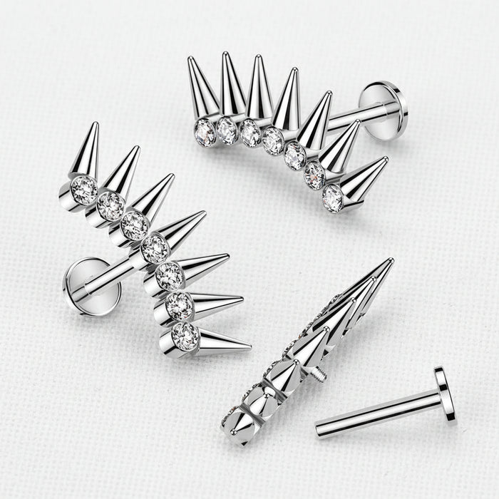 Silver spike earrings with clear gemstones on a light gray background