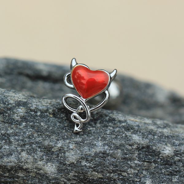 Red heart-shaped pendant with silver design on a stone surface