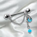 Nipple ring with chain and blue charms on a white satin background