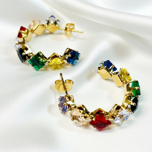 Colorful hoop earrings with gold setting on a light gray background